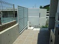 正方形の大きなタイル貼りと背の高い目隠し白フェンスを設置した外構工事の施工例