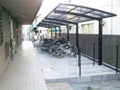 集合住宅に黒い大型自転車置き場（駐輪場）を設置した施工例/下はコンクリート打ちを施しました