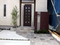 世田谷区で玄関前に茶色いジョリパッド仕上げの門柱を建てたオープン外構の施工例
