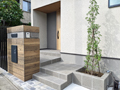 世田谷区でウッド調タイル仕上げの門柱に正方形天然石タイルを床材に施したセミオープン外構の施工画像