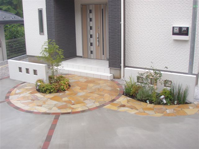 世田谷区 外構工事│玄関前に植栽を配置し、天然石貼りでサークル状のアプローチをデザインしたオープン外構の施工例