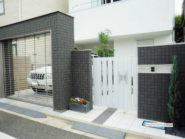 大田区の外構工事 施工例00032│濃いグレーの門柱とシャッターゲートの枠、白い門扉で洋風クローズ外構を仕上げた施工