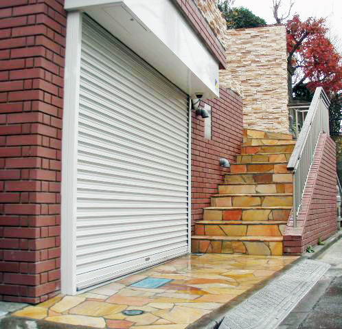 大田区 外構工事│2階玄関へ続く階段をピンクとベージュ系の天然石で全面仕上げた重厚感のある施工事例